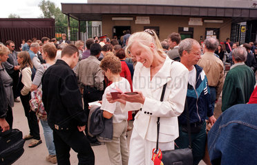 Moskau  junge Frau betrachtet Pass vor der Visastelle der Deutschen Botschaft
