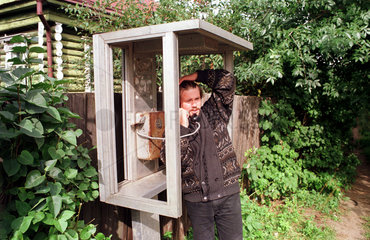 Istra  Mann telefoniert in einer kaputten oeffentlichen Telefonzelle
