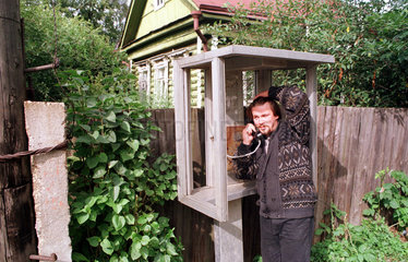 Istra  Mann telefoniert in einer kaputten oeffentlichen Telefonzelle