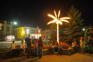 Pastavy  Weissrussland  Jugendliche sitzen abends am zentralen Platz