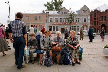Sitzende  wartende Menschen auf einer Bank