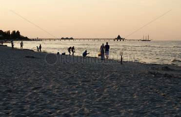 Bansin  Deutschland  Spaziergaenger bei Abenddaemmerung am Strand