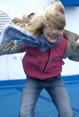 Olbia  Kind stemmt sich gegen den Wind auf einer Faehre
