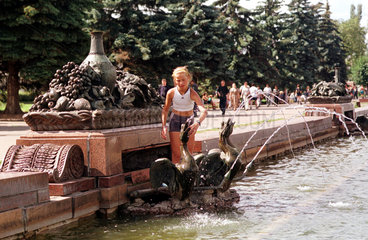 Moskau  ein junges Maedchen spielt in einer Brunnenanlage
