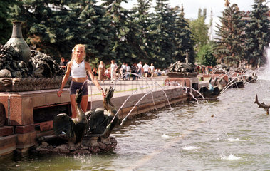 Moskau  ein junges Maedchen spielt in einer Brunnenanlage