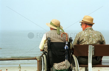 Borkum  Rentnerpaar sitzt an der Strandpromenade und betrachtet die Nordsee