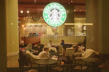 Berlin  Gaeste sitzen in einem Starbucks Cafe