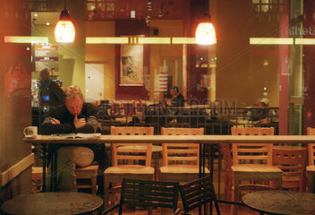 Berlin  Mann sitzt in einem Starbucks Cafe