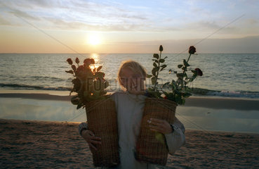 Miedzyzdroje  eine junge Frau mit Rosen am Ostseestrand