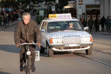 Strassenszene  ein Radfahrer und ein Taxi auf den Strassen von Basel  Schweiz