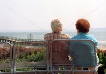 Eckernfoerde  ein Rentnerpaar sitzt auf einer Bank und geniesst den Ausblick