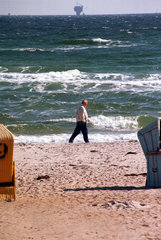 Ein Mann geht am Strand von Damp 2000 spazieren  Deutschland