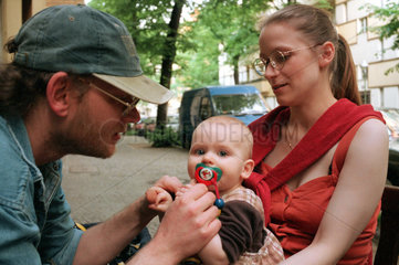 Eltern mit Kind vor ihrem Haus  Berlin  Deutschland