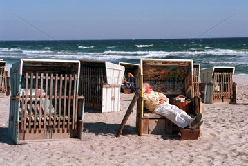 Ein Mann liegt in einem Strandkorb und geniesst die Herbstsonne  Damp 2000  Deutschland