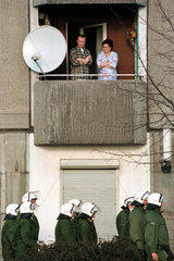 Paar auf dem Balkon  unter ihnen eine Gruppe von Polizisten  Berlin  Deutschland