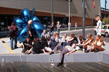 Jugendliche sitzen neben einer Skulptur in Berlin  Deutschland