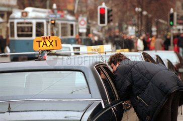 Mann spricht mit einem Taxifahrer in der Zuericher Bahnhofstrasse  Schweiz