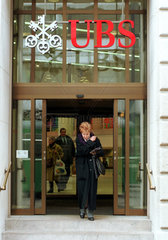 Frau unter dem Logo der Schweizer Bank UBS  Basel  Schweiz