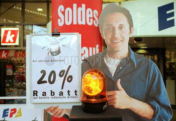 Ein Pappschild mit der Abbildung eines Mannes wirbt vor einem Baseler Kaufhaus fuer reduzierte Artikel  Schweiz