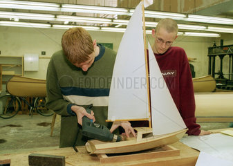 Berlin  ein auszubildender Bootsbauer baut ein Segelbootmodell