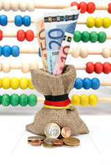 Berlin  Deutschland  Muenzen vor einem kleinen Jutebeutel mit EURO-Geldscheinen