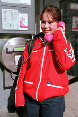 Berlin  Deutschland  Maedchen telefoniert in einer oeffentlichen Telefonzelle