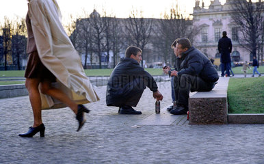 Berlin  drei junge Maenner sitzen auf Steinen im Lustgarten