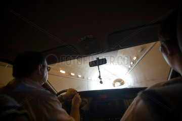 Madrid  Maenner fahren mit einem Auto durch einen Tunnel
