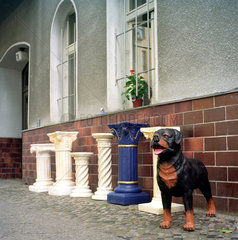 Berlin  Saeulen und Hundefigur aus Kunststoff vor einem Haus