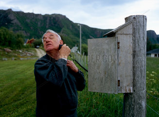 Tonnes  Norwegen  ein aelterer Mann rasiert sich an einem Stromkasten