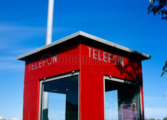 Norwegen  eine rote Telefonzelle vor blauem Himmel