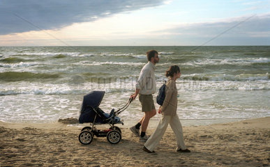 Miedzyzdroje  junges Paar mit Kinderwagen geht am Strand spazieren