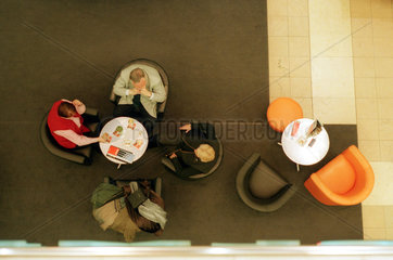 Drei aeltere Menschen in einem Cafe
