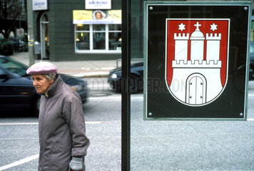 Rentnerin an einer Bushaltestelle in Hamburg