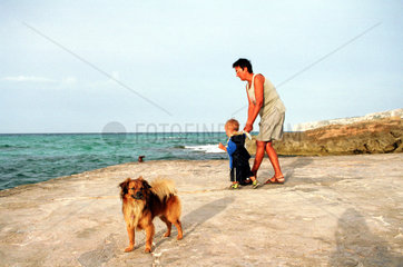 Es Calo  Spanien  Frau mit Kind am Meer mit Hund