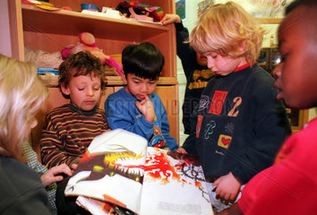 Berlin  Deutschland  Kinder lesen ein Buch in der Kindertagesstaette