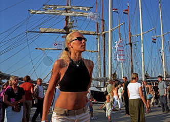 Rostock  eine Frau schaut sich auf der Hanse Sail 2004 um