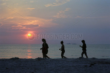 Markgrafenheide  Touristen joggen beim Sonnenuntergang