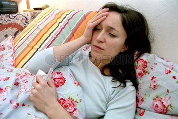 Eine erkrankte Frau mit Kopfschmerzen