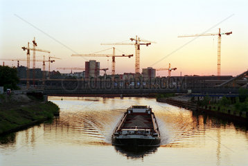 Baukraene und Binnenschiff bei Abendsonne  Berlin  Deutschland