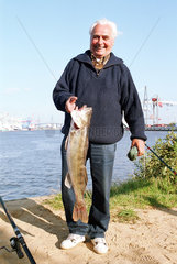 Hamburg  Deutschland  Angler mit grossem Fisch namens Zander