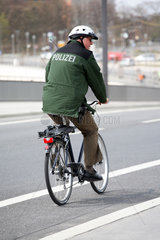 Polizist faehrt Fahrrad