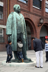 Ruesselsheim  Deutschland  Kinder an der Adam Opel Statue vor dem Eingang