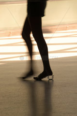 Schlanke Beine einer Frau mit transparentem Absatz