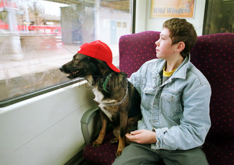 Berlin  Deutschland  Maedchen sitzt mit ihrem Hund in der S-Bahn