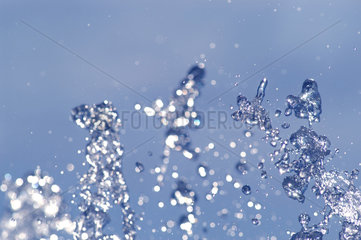 Sprudelndes Wasser vor blauem Hintergrund