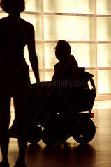 Ein Mann im Rollstuhl schaut zu einer jungen Frau