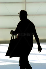 Silhouette eines alten Mannes mit Einkaufsbeuteln