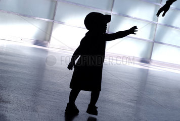 Silhouette eines Kindes  nach einer Hand greifend