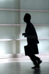 Die Silhouette eines rennenden Mannes mit Aktenkoffer